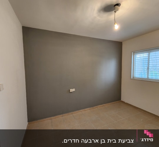 קיר צבוע באפור עם מנורה תלויה מהתקרה